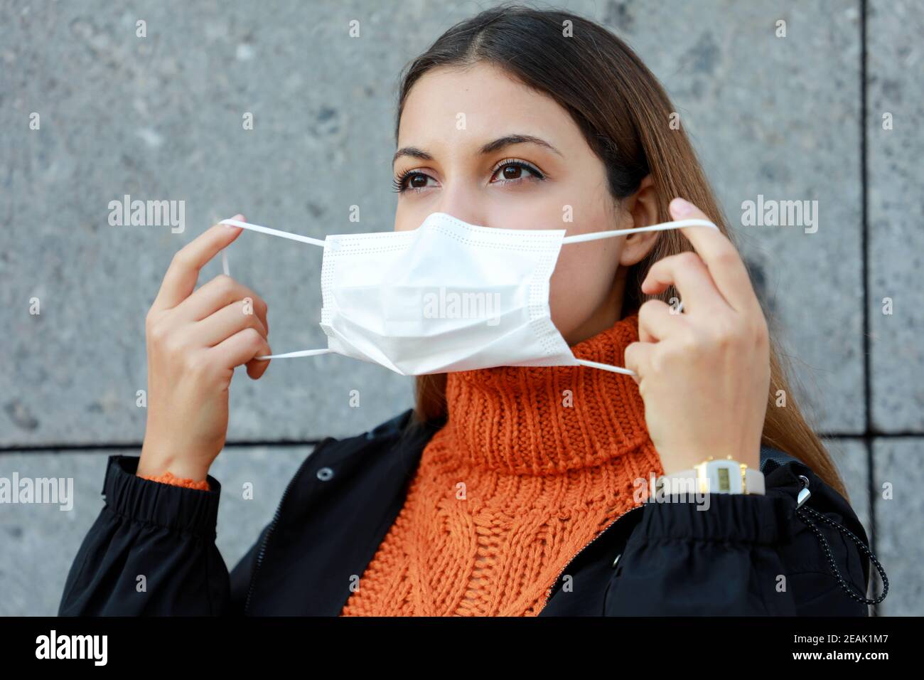 Schöne junge Frau trägt Schutzmaske in der Stadt Straße Stockfoto