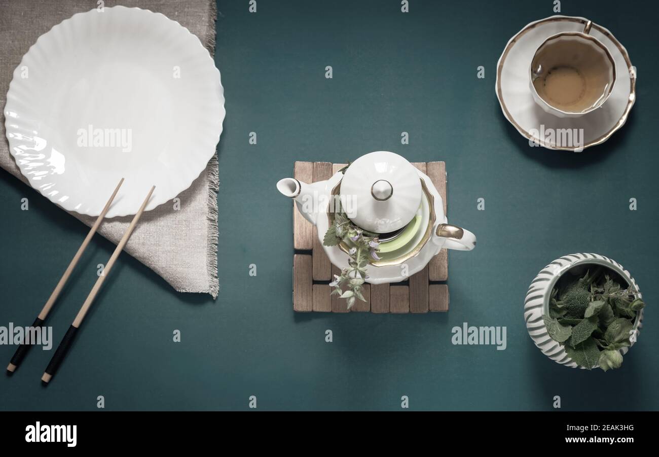 Leere weiße Teller, Essstäbchen und Kräutertee Stockfoto