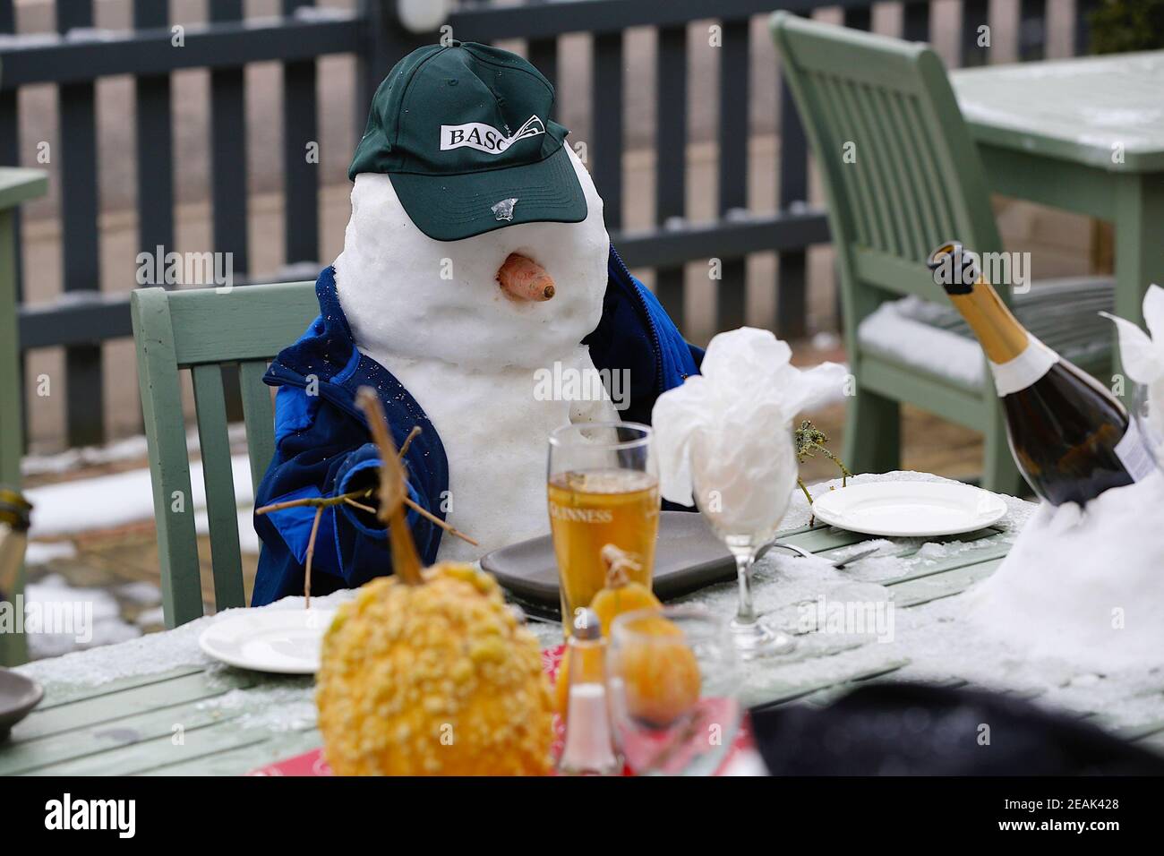 Ashford, Kent, Großbritannien. 10. Februar 2021. Aufgrund der Pandemie musste das Chequers on the Green Pub an der Ashford Rd A28 in High Halden schließen und hat eine neuartige Möglichkeit entwickelt, Passanten mit Schnee zu amüsieren, der von Storm Darcy kommt. Eine Familie von Schneefiguren sitzt draußen, trinkt und isst. Foto-Kredit: Paul Lawrenson/Alamy Live Nachrichten Stockfoto