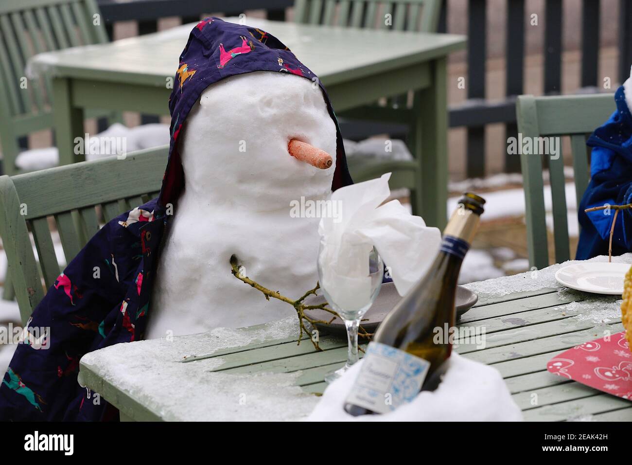 Ashford, Kent, Großbritannien. 10. Februar 2021. Aufgrund der Pandemie musste das Chequers on the Green Pub an der Ashford Rd A28 in High Halden schließen und hat eine neuartige Möglichkeit entwickelt, Passanten mit Schnee zu amüsieren, der von Storm Darcy kommt. Eine Familie von Schneefiguren sitzt draußen, trinkt und isst. Foto-Kredit: Paul Lawrenson/Alamy Live Nachrichten Stockfoto