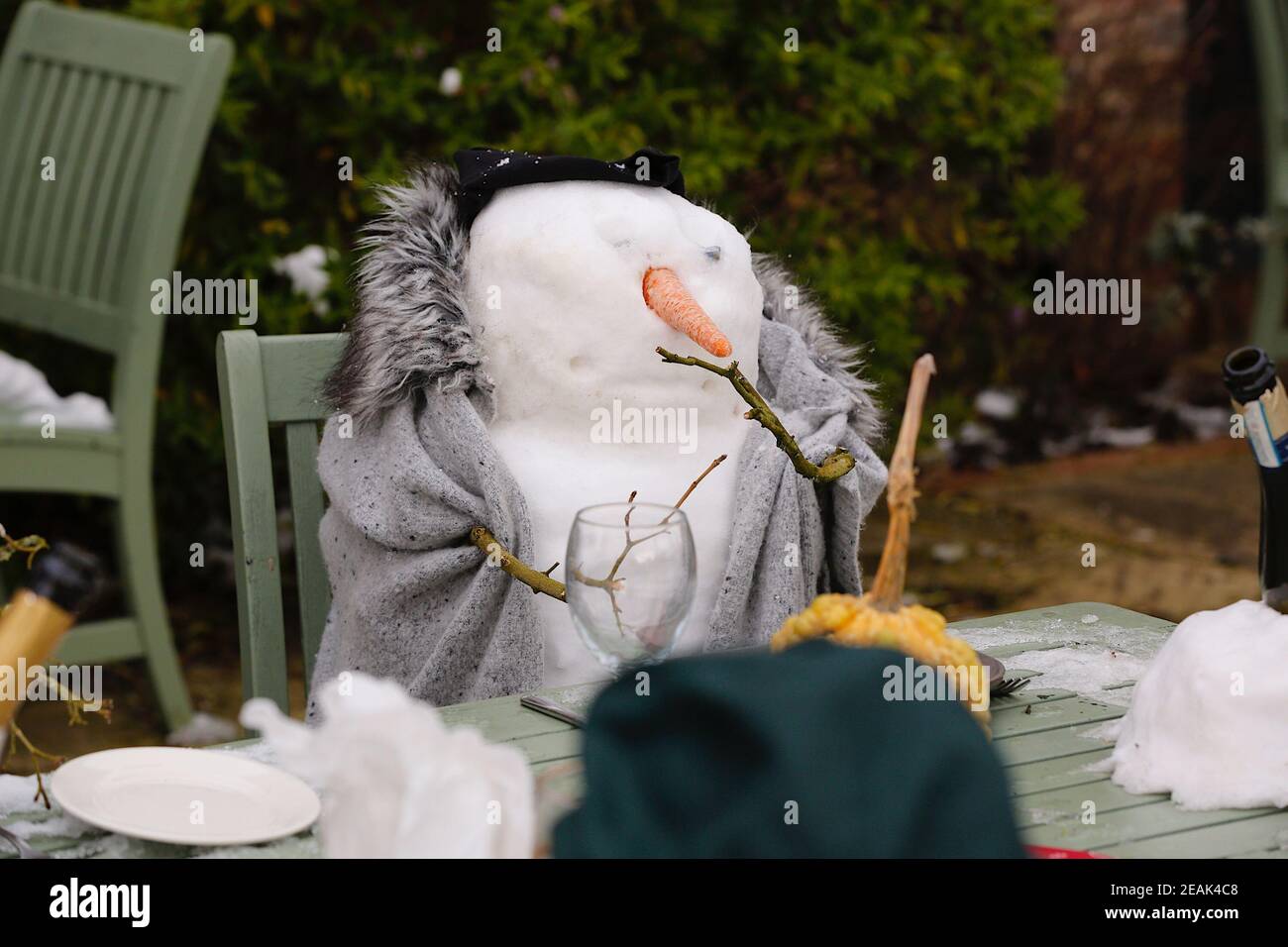 Ashford, Kent, Großbritannien. 10. Februar 2021. Aufgrund der Pandemie musste das Chequers on the Green Pub an der Ashford Rd A28 in High Halden schließen und hat eine neuartige Möglichkeit entwickelt, Passanten mit Schnee zu amüsieren, der von Storm Darcy kommt. Eine Familie von Schneefiguren sitzt draußen, trinkt und isst. Foto-Kredit: Paul Lawrenson/Alamy Live Nachrichten Stockfoto