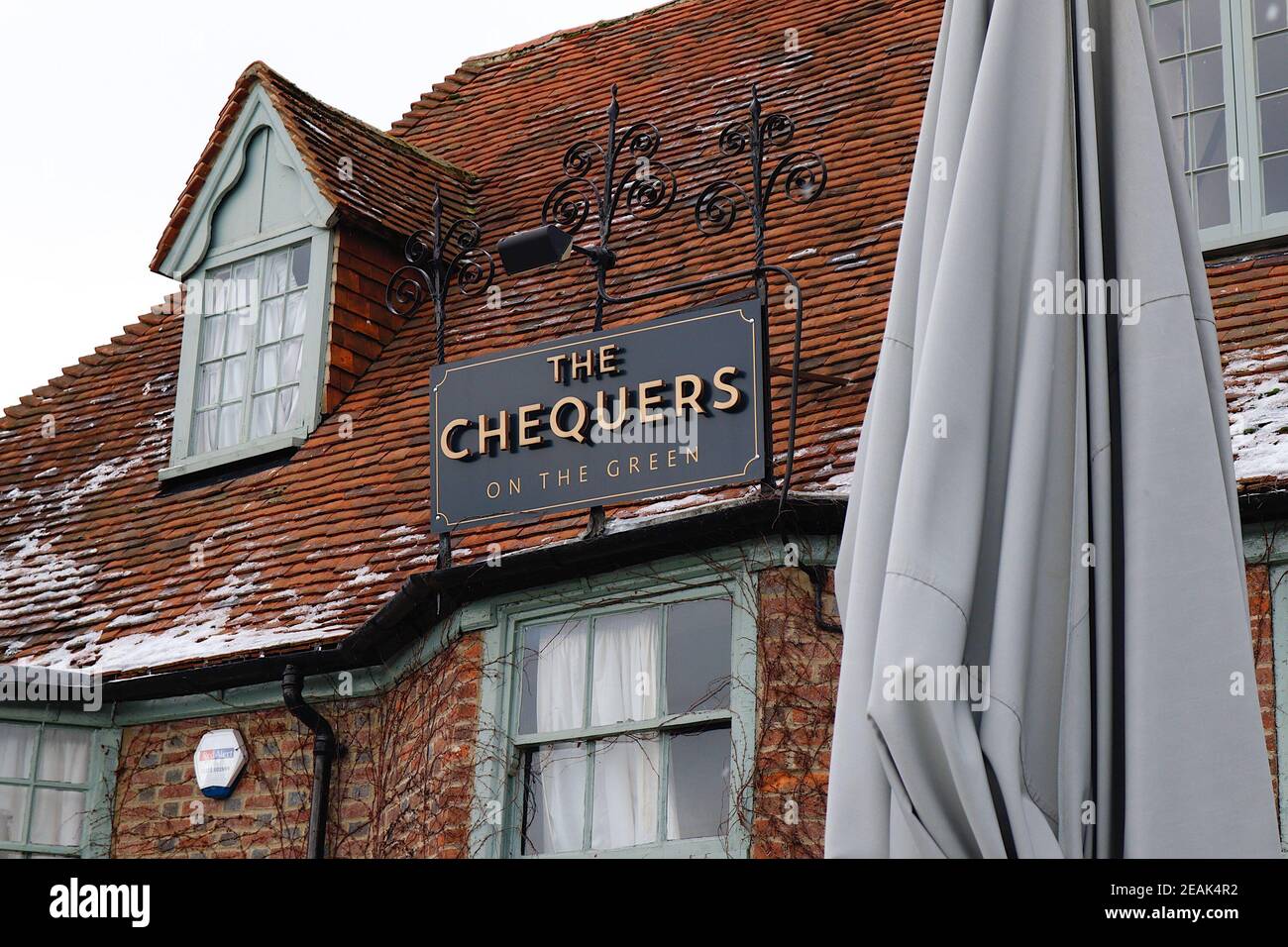 Ashford, Kent, Großbritannien. 10. Februar 2021. Aufgrund der Pandemie musste das Chequers on the Green Pub an der Ashford Rd A28 in High Halden schließen und hat eine neuartige Möglichkeit entwickelt, Passanten mit Schnee zu amüsieren, der von Storm Darcy kommt. Eine Familie von Schneefiguren sitzt draußen, trinkt und isst. Foto-Kredit: Paul Lawrenson/Alamy Live Nachrichten Stockfoto