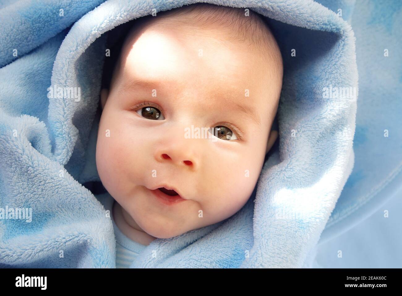 drei Monate altes Baby eingehüllt in blaue Decke Stockfoto