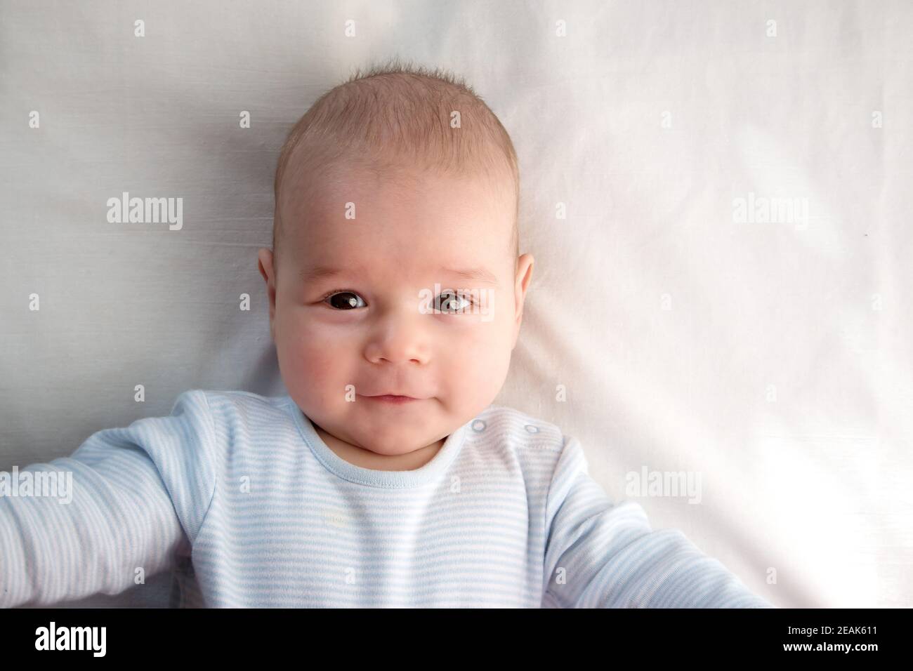 drei Monate altes Baby eingehüllt in blaue Decke Stockfoto