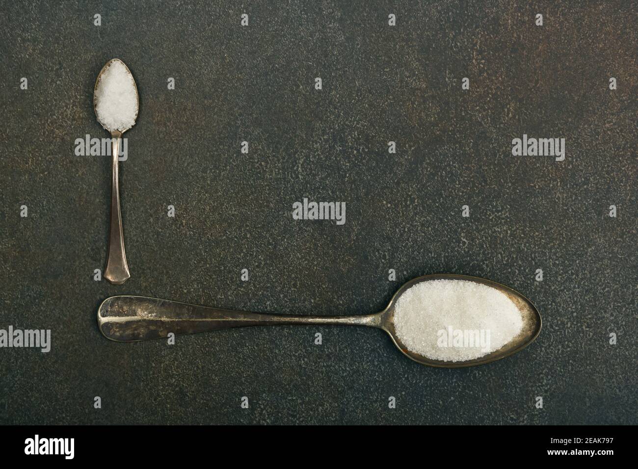 Zwei Löffel Zucker und Salz auf dem Tisch Stockfoto