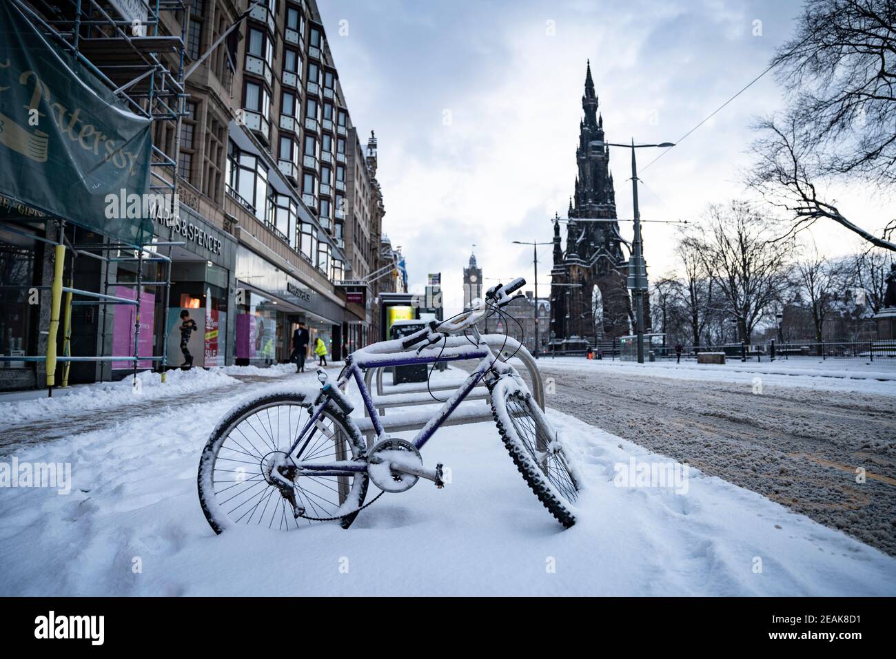 Edinburgh, Schottland, Großbritannien. Februar 2021, 10. Große Frost in Großbritannien mit schweren Nacht-und Morgenschnee in der Stadt weiter. PIC; schneebedecktes Fahrrad auf der Princes Street. Iain Masterton/Alamy Live Nachrichten Stockfoto