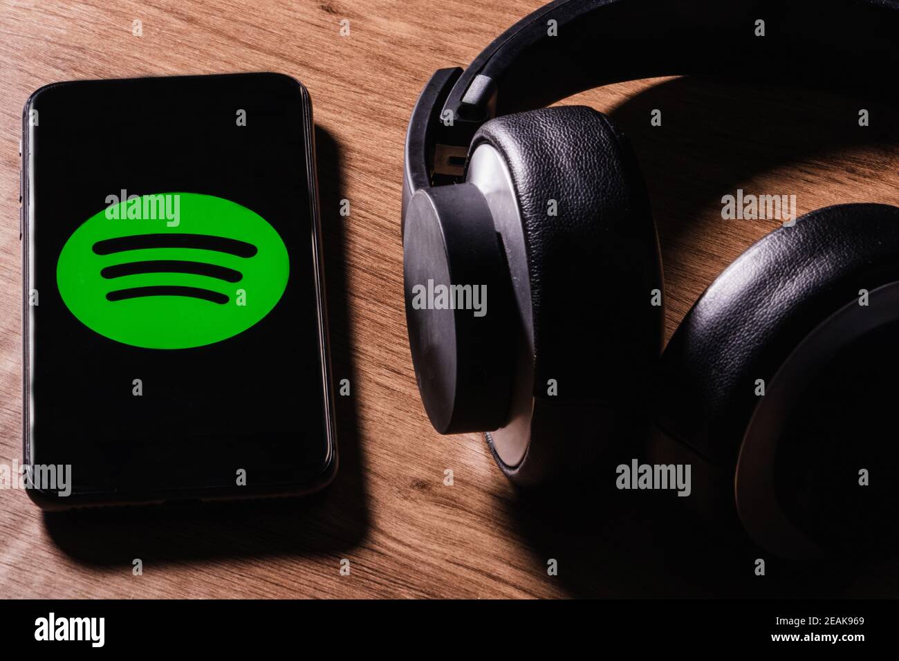 MADRID, SPANIEN - 09. Feb 2021: MADRID, SPANIEN - 09. FEBRUAR 2021:Flat Lay von Kopfhörer und Smartphone mit Spotify App-Symbol auf dem Bildschirm ist eine der popula Stockfoto