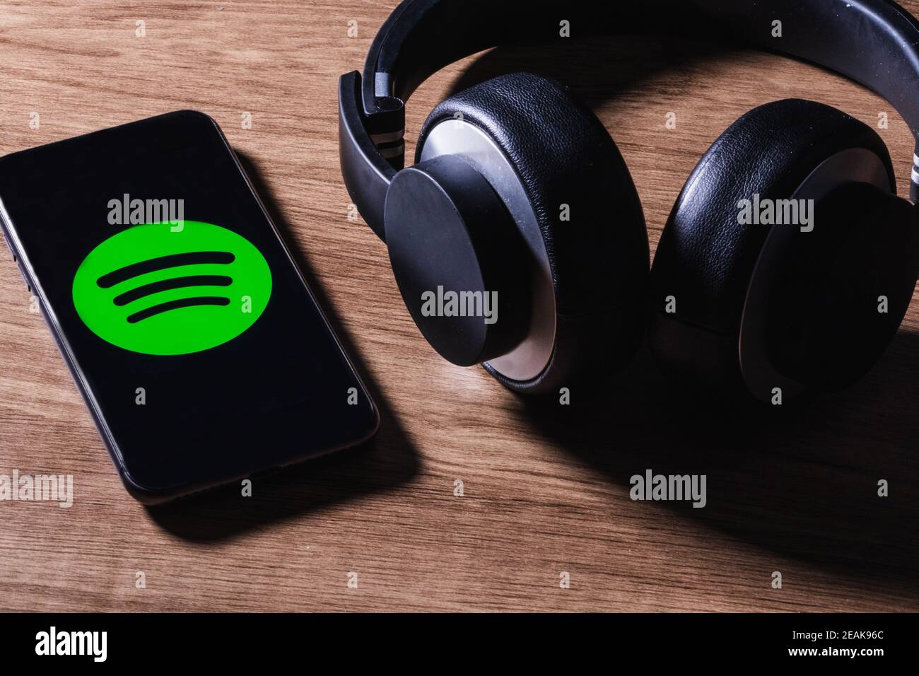 MADRID, SPANIEN - 09. Feb 2021: MADRID, SPANIEN - 09. FEBRUAR 2021:Flat Lay von Kopfhörer und Smartphone mit Spotify App-Symbol auf dem Bildschirm, ist einer der popul Stockfoto