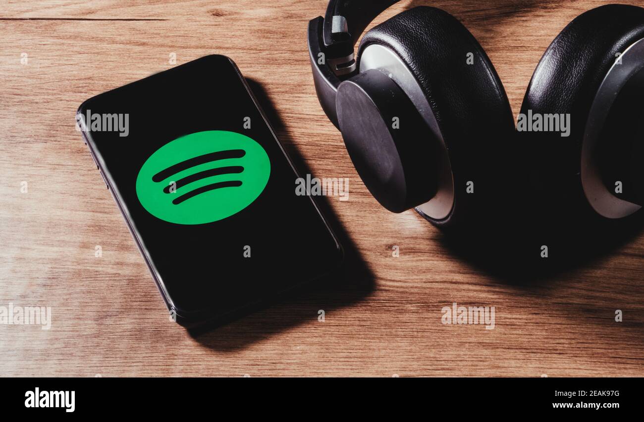 MADRID, SPANIEN - 09. Feb 2021: MADRID, SPANIEN - 09. FEBRUAR 2021:Flat Lay von Kopfhörer und Smartphone mit Spotify App-Symbol auf dem Bildschirm, ist einer der popula Stockfoto