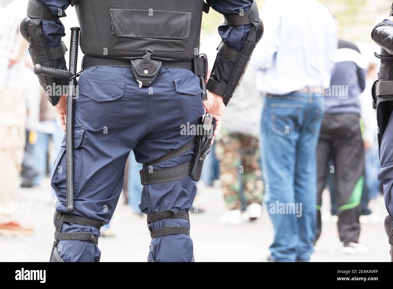 Bereitschaftspolizist hält während des Straßenprotests Hand an seiner Waffe Stockfoto