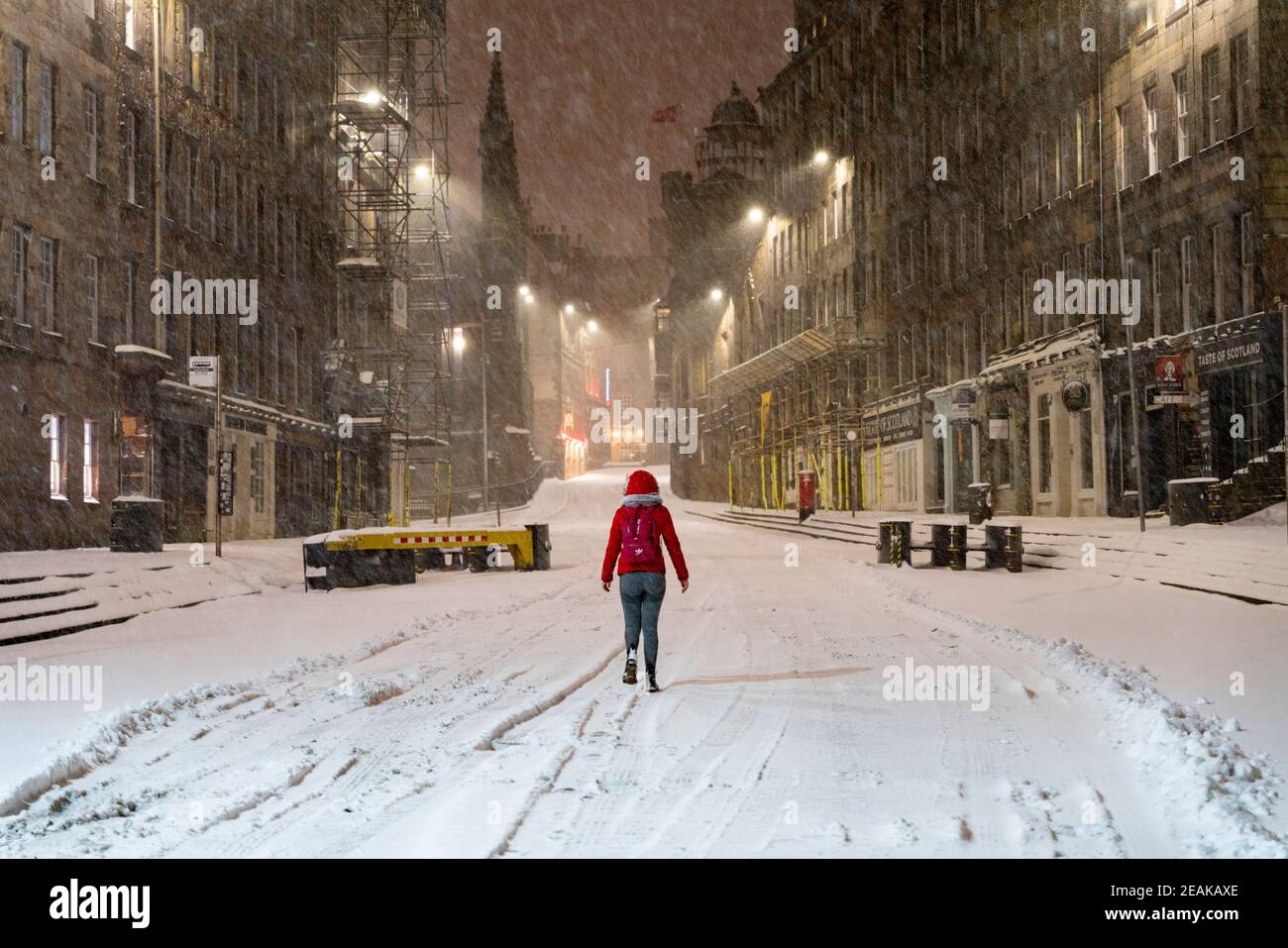Edinburgh, Schottland, Großbritannien. Februar 2021, 10. Große Frost in Großbritannien mit schweren Nacht-und Morgenschnee in der Stadt weiter. PIC; Lone Mitglied der Öffentlichkeit auf der Royal Mile bei Lawnmarket in den frühen Morgenschneeszards. Iain Masterton/Alamy Live Nachrichten Stockfoto