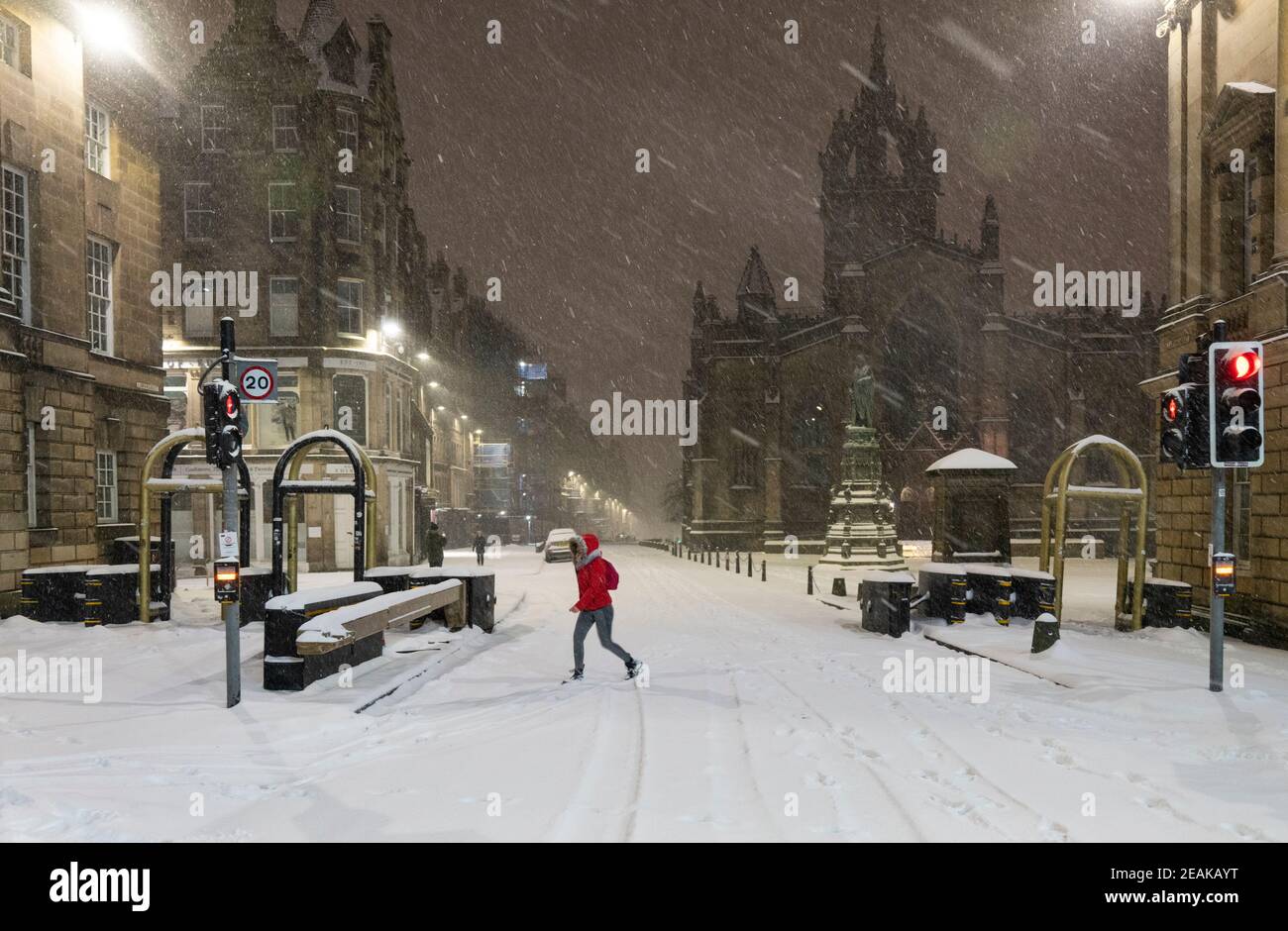 Edinburgh, Schottland, Großbritannien. Februar 2021, 10. Große Frost in Großbritannien mit schweren Nacht-und Morgenschnee in der Stadt weiter. PIC; Lone Mitglied der Öffentlichkeit auf der Royal Mile in den frühen Morgen Schneesturm. Iain Masterton/Alamy Live Nachrichten Stockfoto