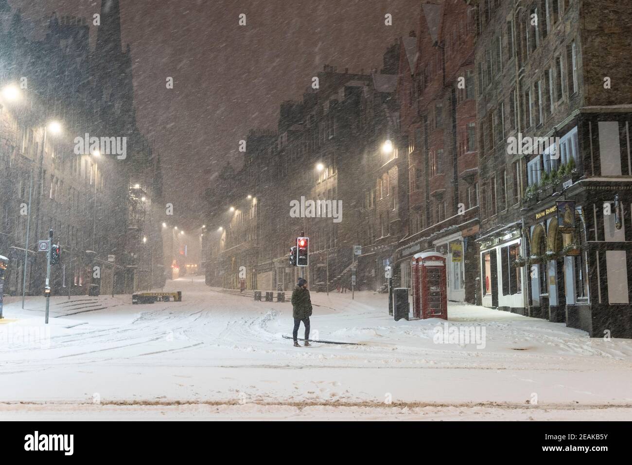Edinburgh, Schottland, Großbritannien. Februar 2021, 10. Große Frost in Großbritannien mit schweren Nacht-und Morgenschnee in der Stadt weiter. PIC; Lone Mitglied der Öffentlichkeit auf der Royal Mile bei Lawnmarket in den frühen Morgenschneeszards. Iain Masterton/Alamy Live Nachrichten Stockfoto
