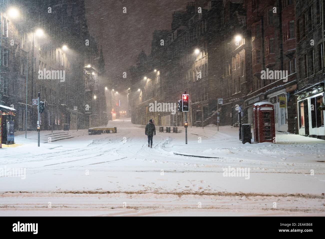 Edinburgh, Schottland, Großbritannien. Februar 2021, 10. Große Frost in Großbritannien mit schweren Nacht-und Morgenschnee in der Stadt weiter. PIC; Lone Mitglied der Öffentlichkeit auf der Royal Mile bei Lawnmarket in den frühen Morgenschneeszards. Iain Masterton/Alamy Live Nachrichten Stockfoto