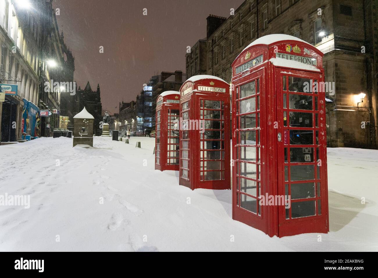 Edinburgh, Schottland, Großbritannien. Februar 2021, 10. Große Frost in Großbritannien mit schweren Nacht-und Morgenschnee in der Stadt weiter. Bild: Drei Telefonzellen auf einer leeren Royal Mile im frühen Morgenschnee. Iain Masterton/Alamy Live Nachrichten Stockfoto