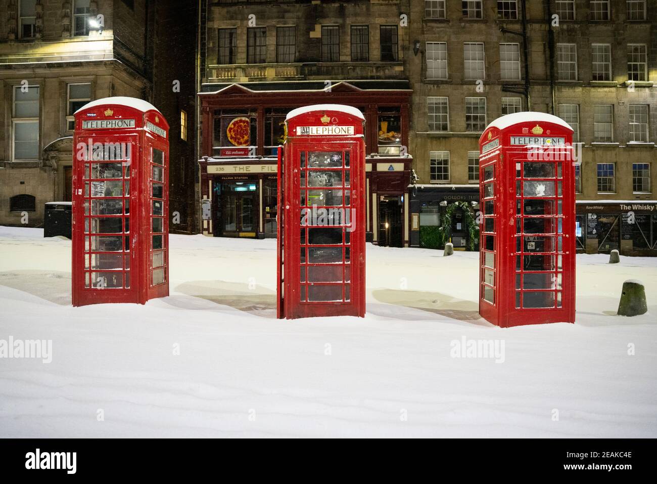 Edinburgh, Schottland, Großbritannien. Februar 2021, 10. Große Frost in Großbritannien mit schweren Nacht-und Morgenschnee in der Stadt weiter. Bild: Drei Telefonzellen auf einer leeren Royal Mile im frühen Morgenschnee. Iain Masterton/Alamy Live Nachrichten Stockfoto