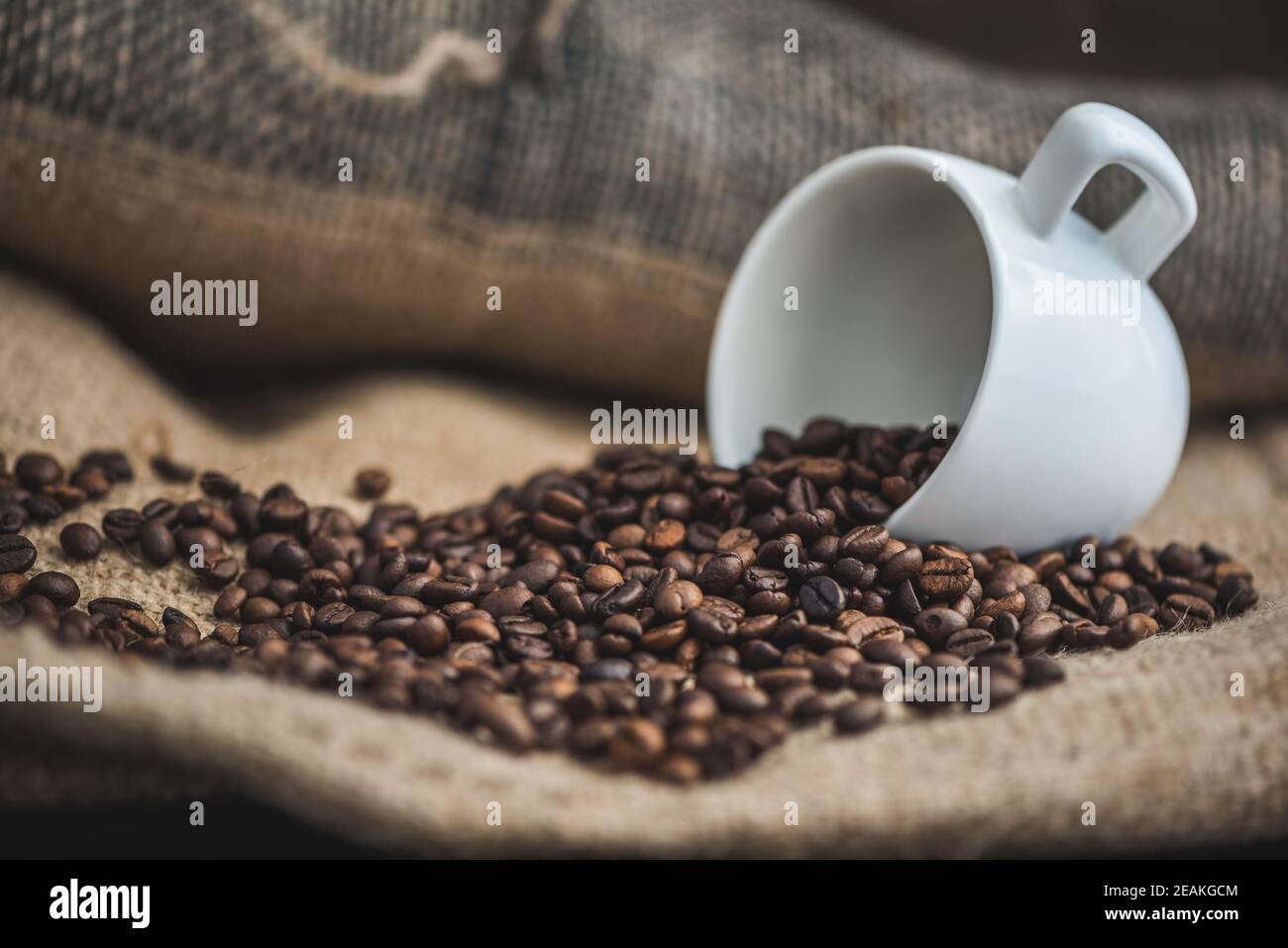 Kaffeebohnen verschüttet aus Tasse Stockfoto