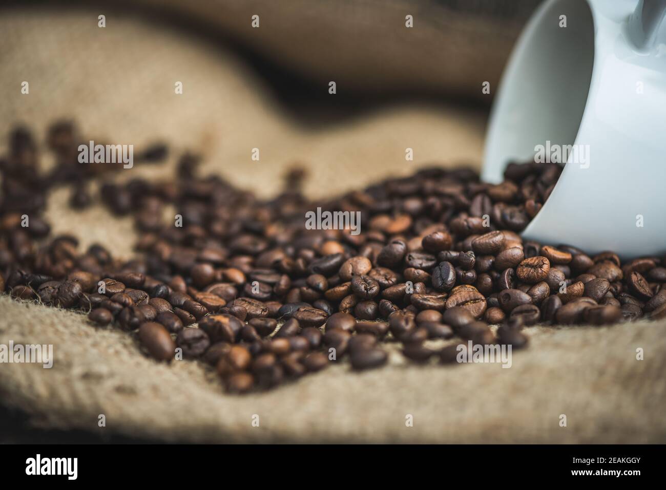 Kaffeebohnen verschüttet aus Tasse Stockfoto