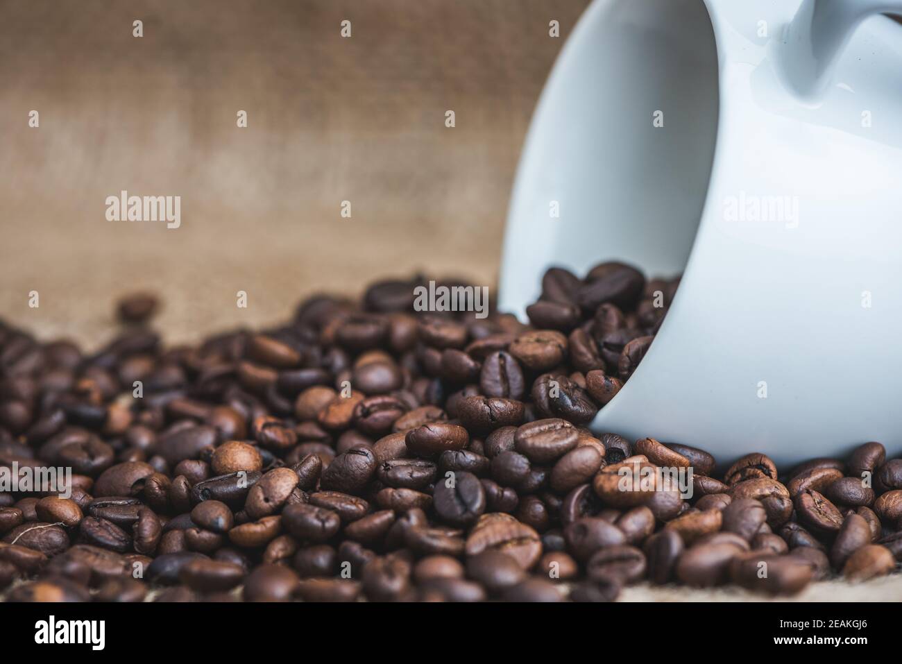 Kaffeebohnen verschüttet aus Tasse Stockfoto
