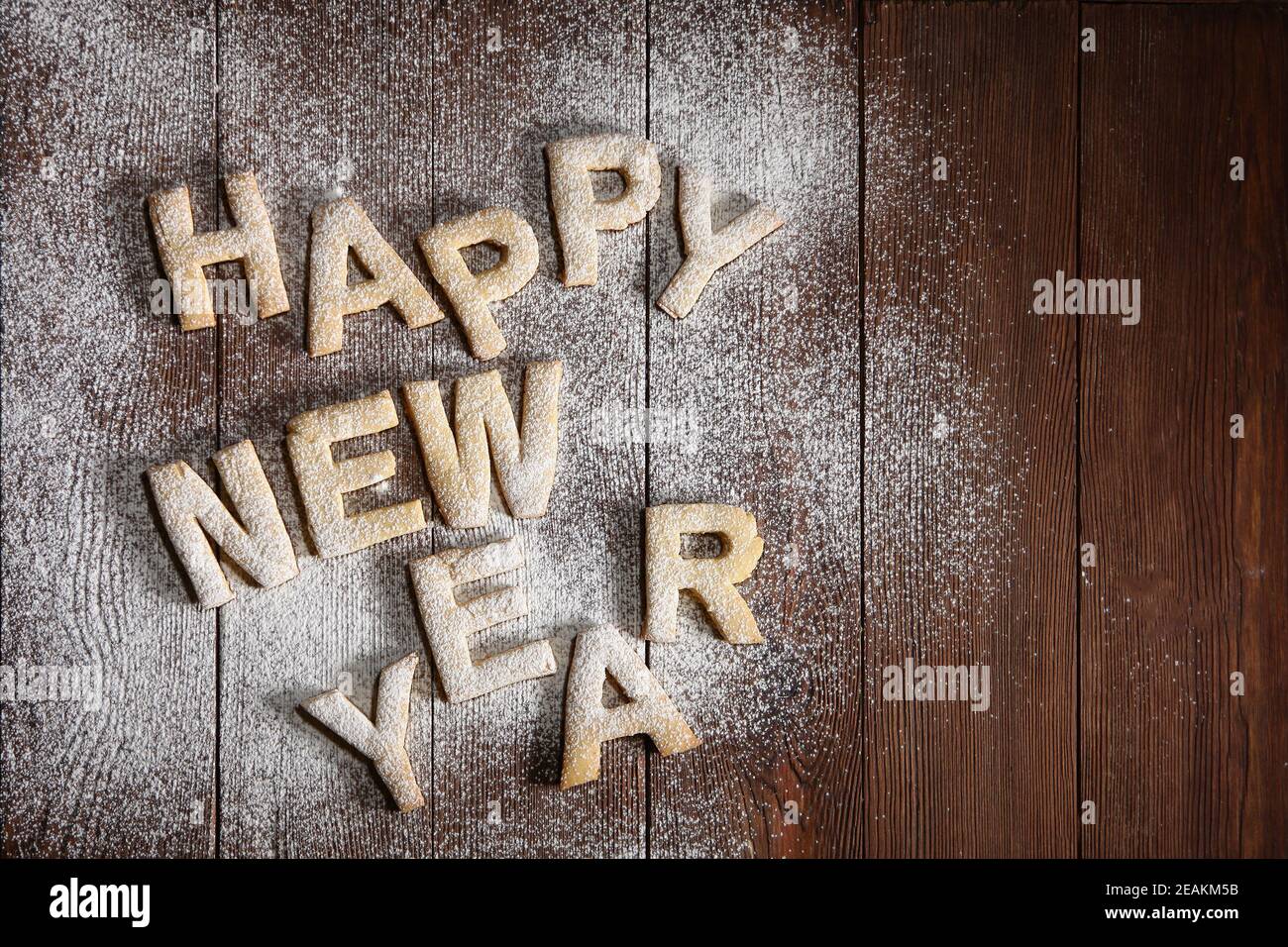 Die Inschrift Happy New Year-Kekse in Form von Buchstaben aus Ingwerteig. Ingwer-Kekse, Neujahr-Konzept . Handarbeit. Der Druck ist wie eine Schablone.Draufsicht. Stockfoto