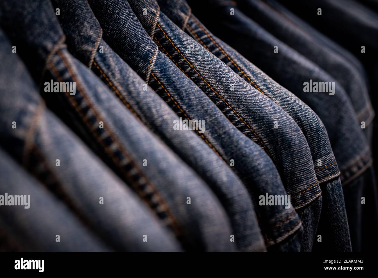 Selektiver Fokus auf Jacke Jeans hängen auf Rack im Bekleidungsgeschäft. Jeans mit Jeans-Muster. Textilindustrie. Jeans Mode und Shopping Konzept. Bekleidungskonzept. Jeansjacke auf Rack zum Verkauf. Stockfoto