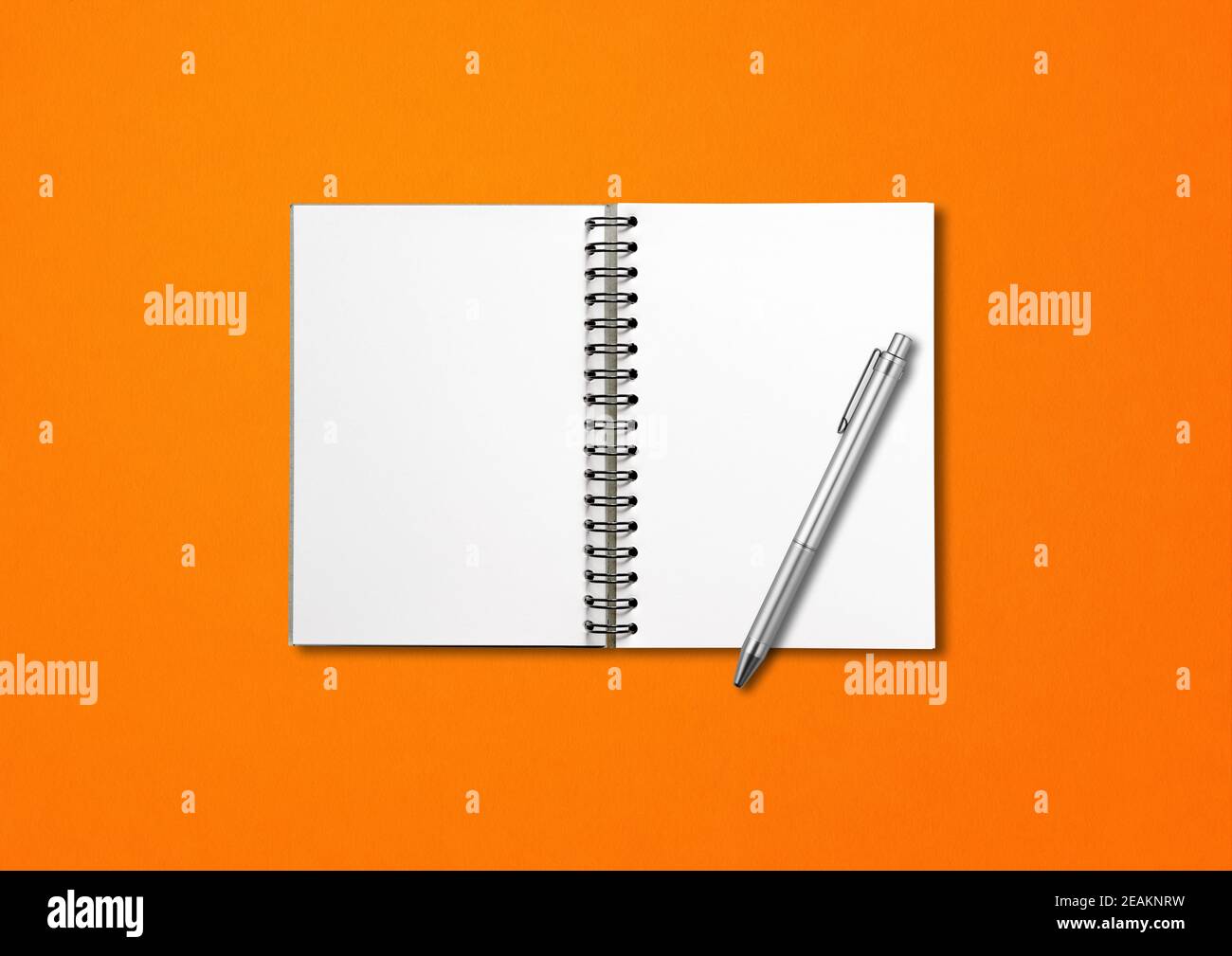Blank offene Spirale Notizbuch und Stift isoliert auf orange Stockfoto