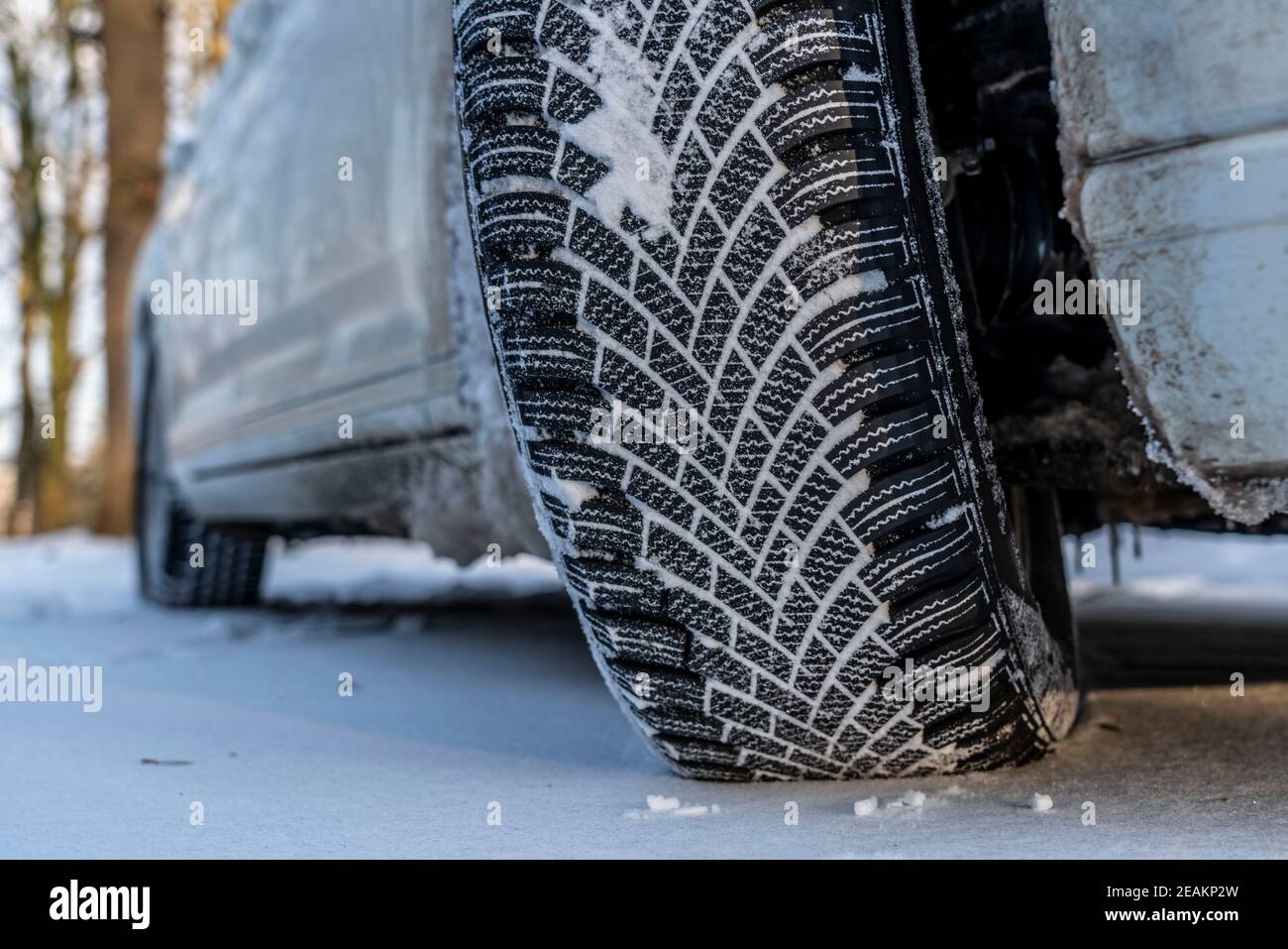 Winterreifen, Fahren auf einer Straße mit Schneedecke, Grip auf dem Schnee durch die spezielle Lauffläche und Gummimischung, der Reifen für den Winter, Stockfoto