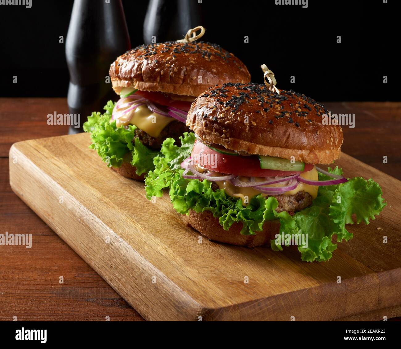 burger mit gebratenem Rinderschnitzel und Zwiebeln, knuspriges Weizenmehl-Brötchen mit Sesam Stockfoto