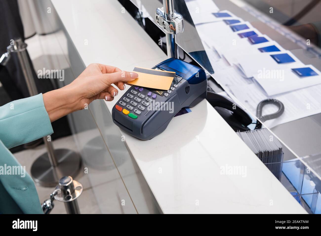 Beschnittene Ansicht der Frau, die mit Kreditkarte und Zahlung bezahlt Terminal im Hotel Stockfoto
