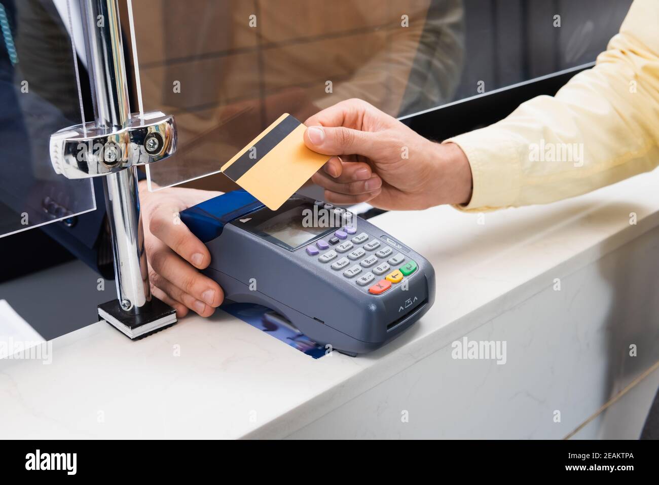 Kurzer Blick auf den Mann mit Kreditkarte in der Nähe des Hotelmanagers Mit Terminal Stockfoto