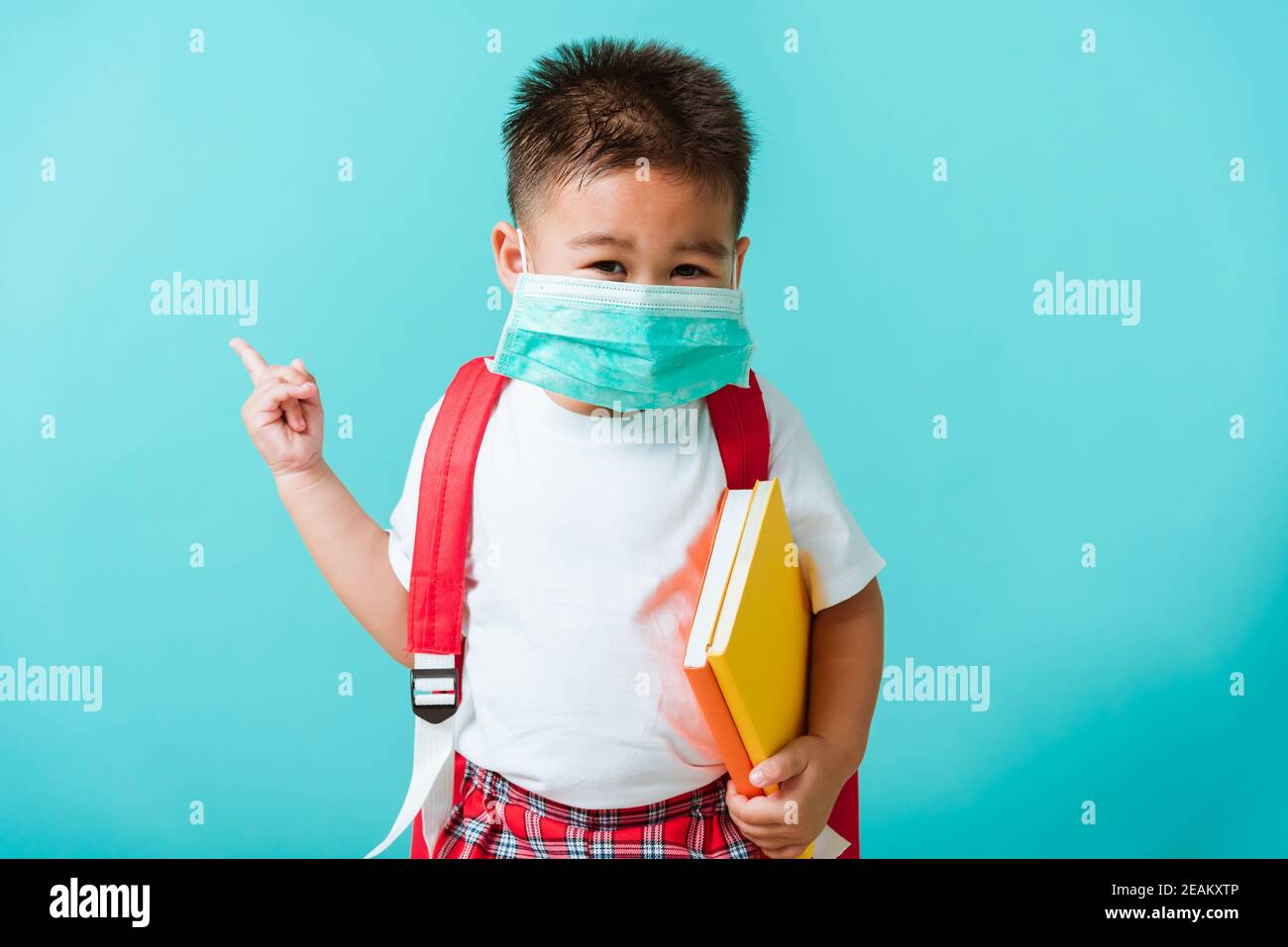 Kind Junge Kindergarten tragen Gesichtsmaske Schutz und Schultasche Vor der Schule Stockfoto