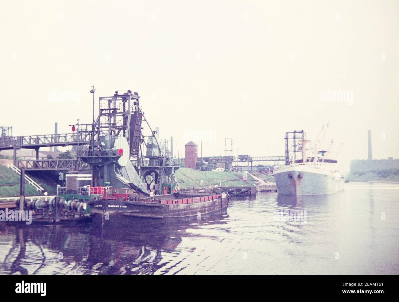 1973 Manchester Schiff Canal Mode Radschlösser Manchester mit Ladedocks Lastkähne und Frachtschiff. Waggons können gesehen werden, wie sie Ladung in das große Schiff kippen, das hinter dem Lastkahn angedockt ist. Manchester England GB UK Europa Stockfoto