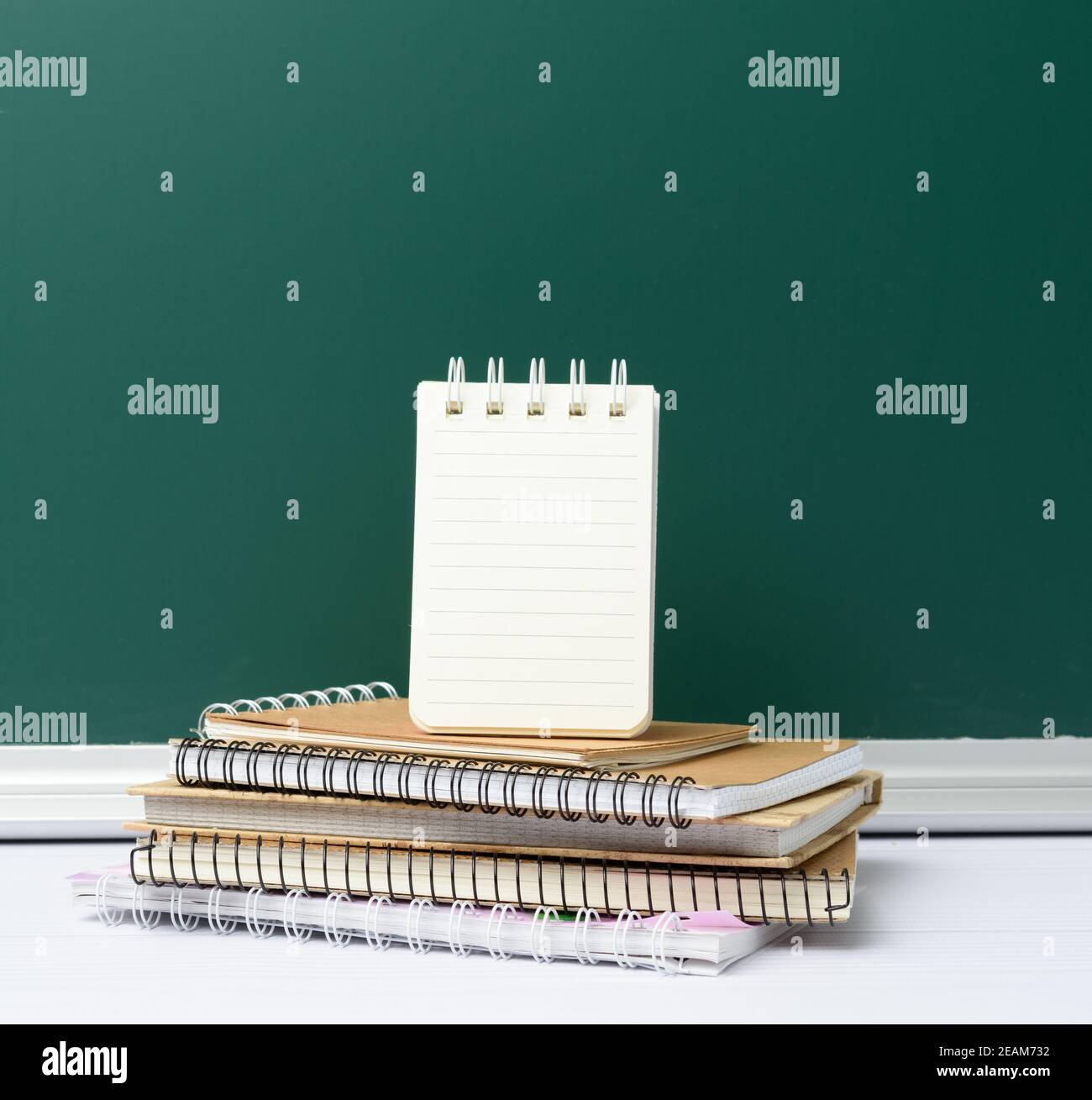 Leere grüne Kreide Schultafel und Stapel von Notebooks, zurück zur Schule Stockfoto