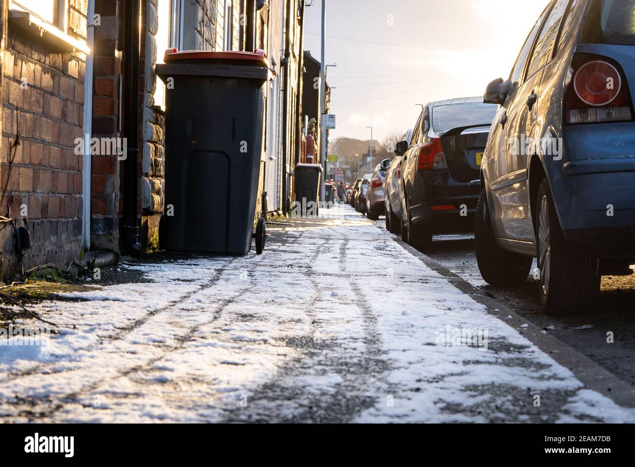 Gefrorener eisiger öffentlicher Straßenbelag gefährlicher Zustand für Fußgänger zu Fuß In der Winterstadt ließ sich kein Salzstreu nieder, der Schnee verbreitete Rutschiges Eis Stockfoto