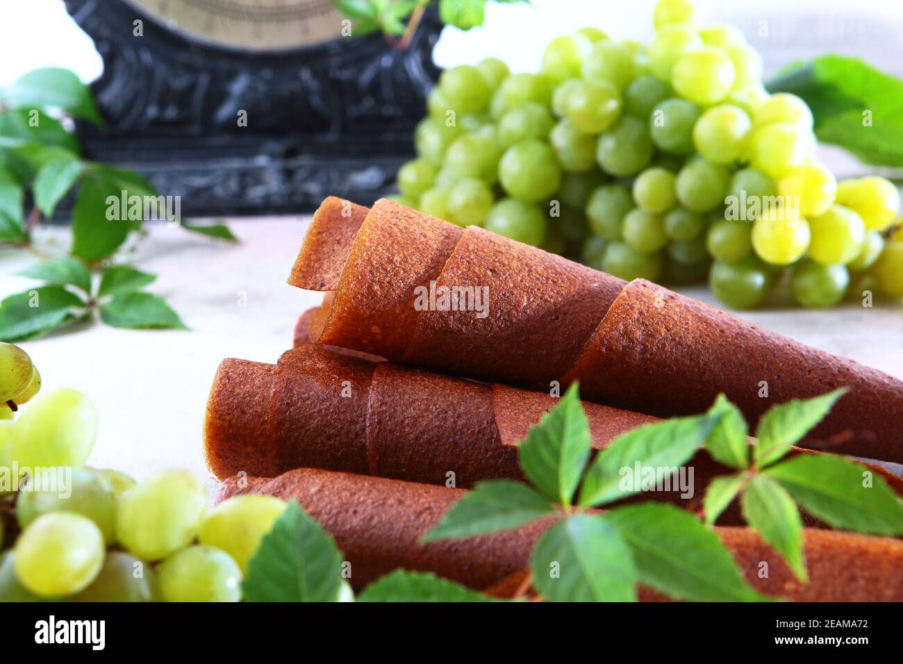 Pastilla aus Trauben. Naturprodukt ohne Konservierungsstoffe. Essen für Vegetarier. Trauben auf hellem Hintergrund. Vintage Skalen im Hintergrund. Stockfoto