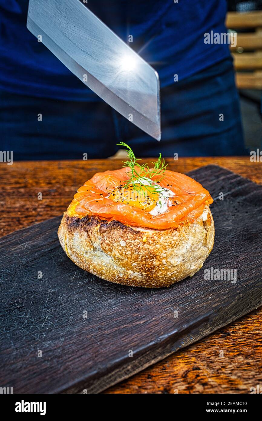 Gefüllte Brotlaibe gefüllt mit geräuchertem Lachs, crème fraiche, Spinat, langsam gerösteten Tomaten, Lauch und Käse. Stockfoto