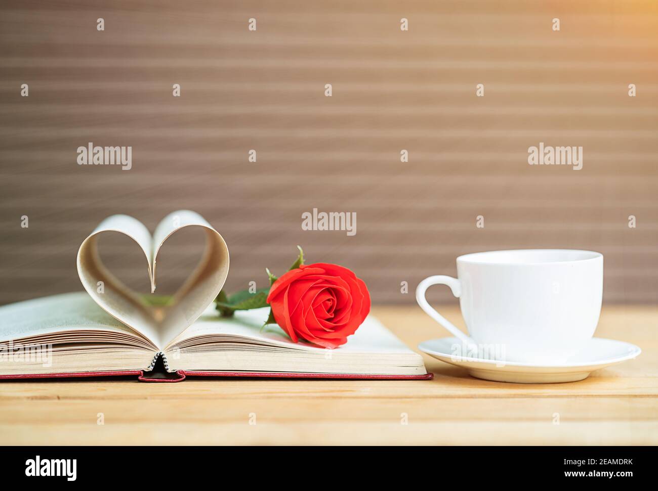 Buchseite gebogene Herzform und rote Rose Stockfoto