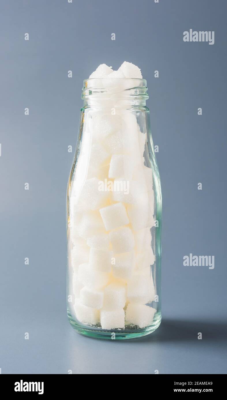 Glasflasche voll mit weißem Zuckerwürfel Stockfoto