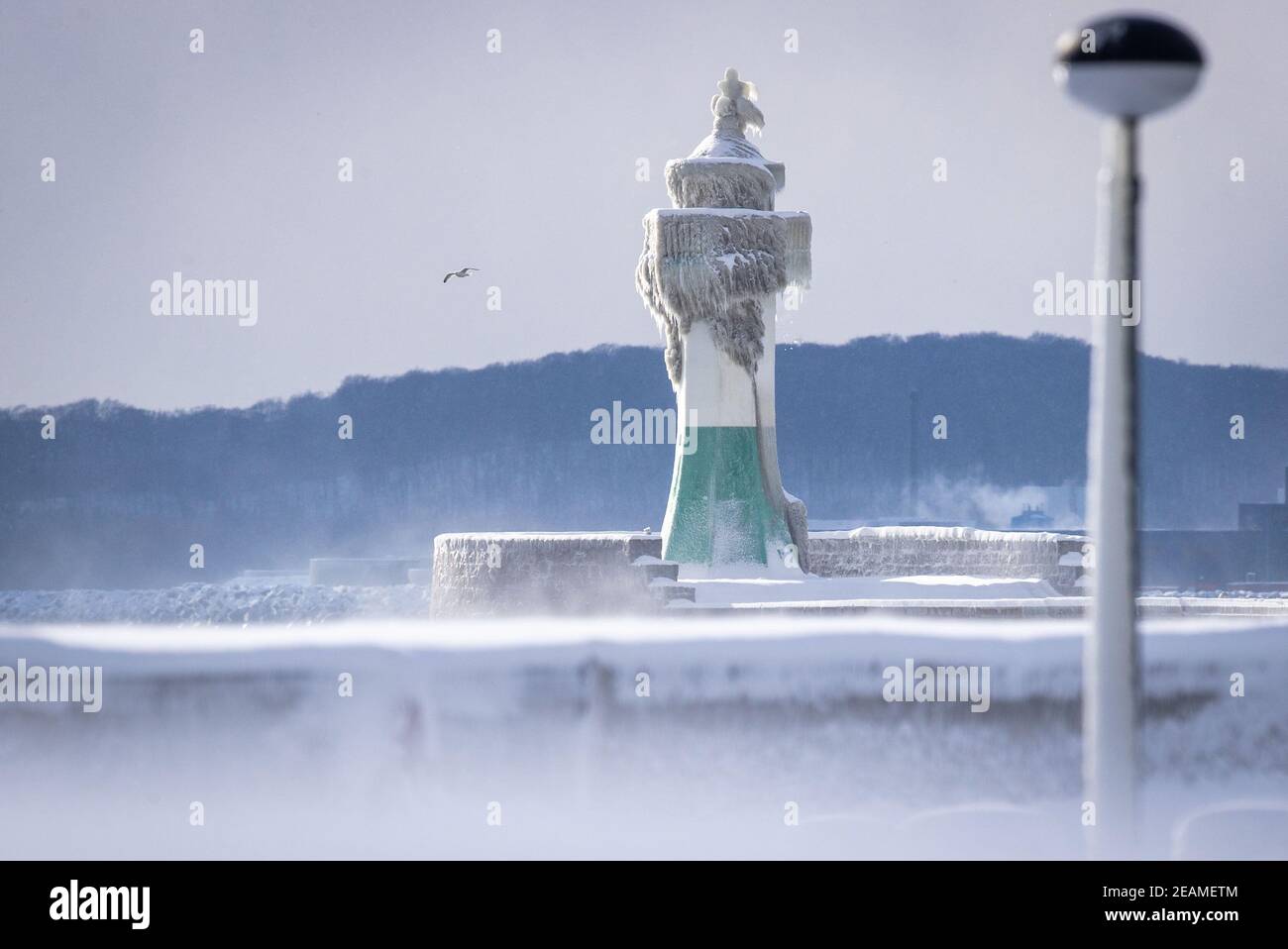 Sassnitz, Deutschland. Februar 2021, 10th. Der eisige Leuchtturm am Pier der Hafeneinfahrt. Frostiges Wetter und Schneefall behindern den Verkehr in Norddeutschland. Quelle: Jens Büttner/dpa-Zentralbild/dpa/Alamy Live News Stockfoto