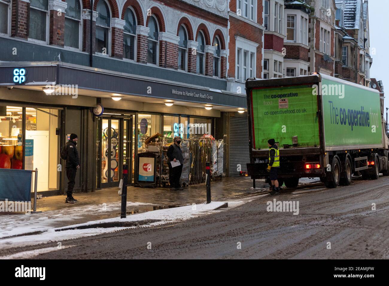 Lieferung von Lebensmitteln in den frühen Morgenstunden für Co-op-Supermarkt in Hamlet Court Road, Westcliff on Sea, Essex, UK, mit Schnee von Storm Darcy. Vereiste Straße Stockfoto