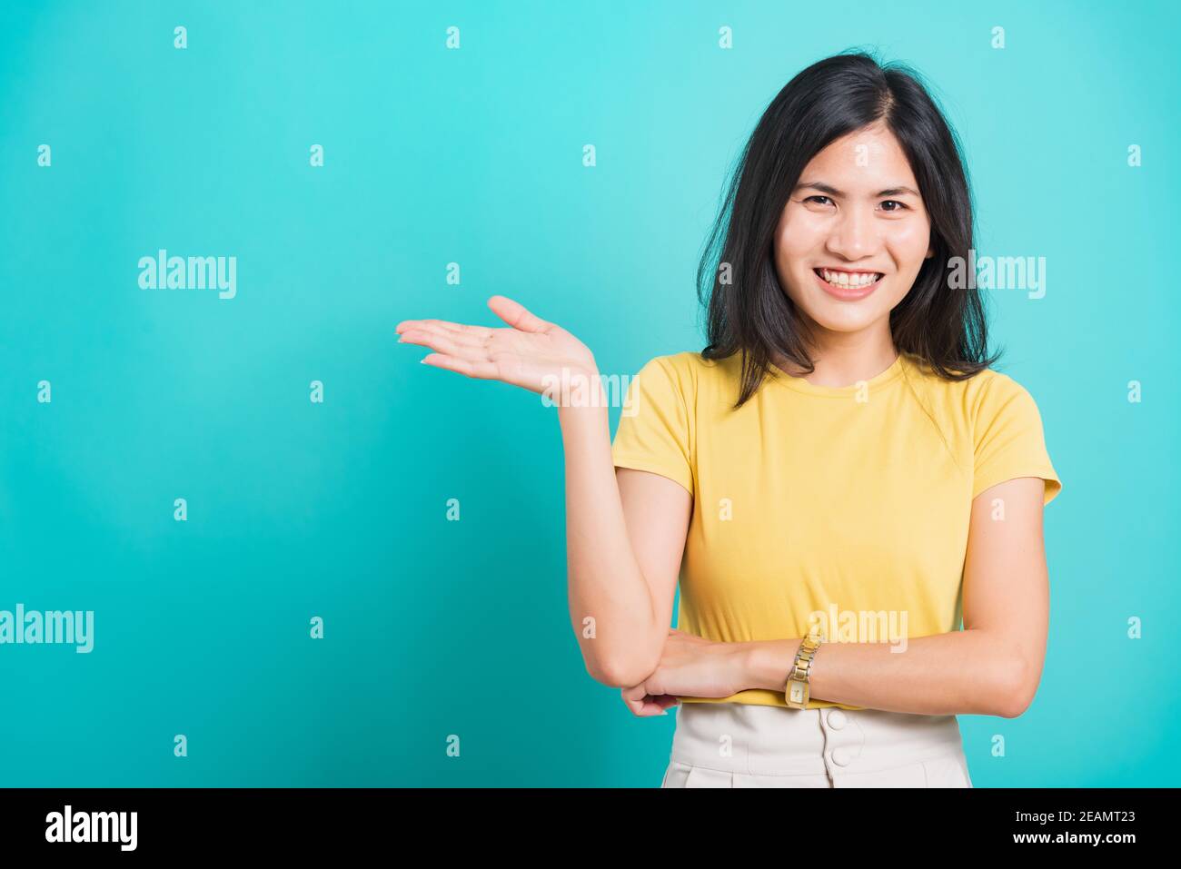 Junge Frau stehend zeigt Hand präsentiert Produkt Stockfoto