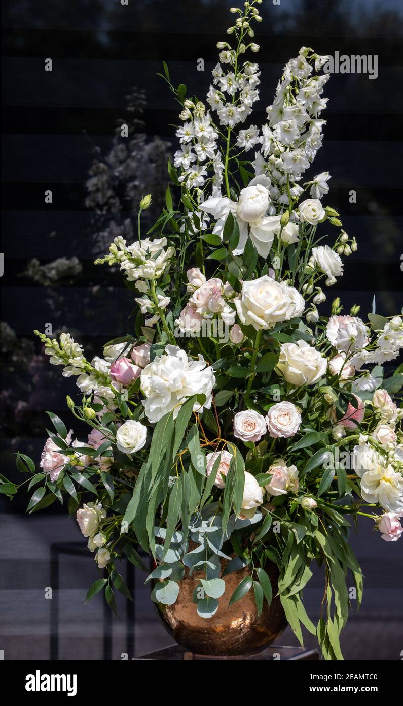 Beeindruckendes floristisches Bouquet von weißen Rosen und Delphinium - grün Drehen Stockfoto