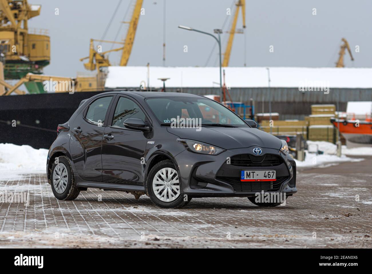 Riga, Lettland - 9. Februar 2021: Graumetallisches Toyota Yaris Hybrid Y20 Edition Auto auf einem industriellen Hintergrund Stockfoto