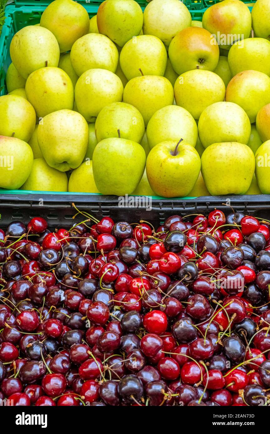 Kirschen und Äpfel zum Verkauf auf einem Markt Stockfoto