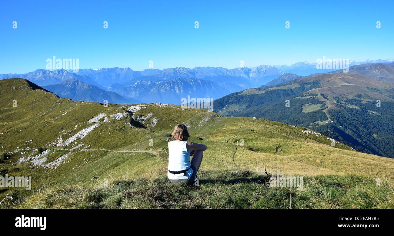 Frau mit Blick auf die Berge und die Alpen vom Monte Guglielmo. Lago d'Iseo, Brescia, Lombardei, Italien. Stockfoto