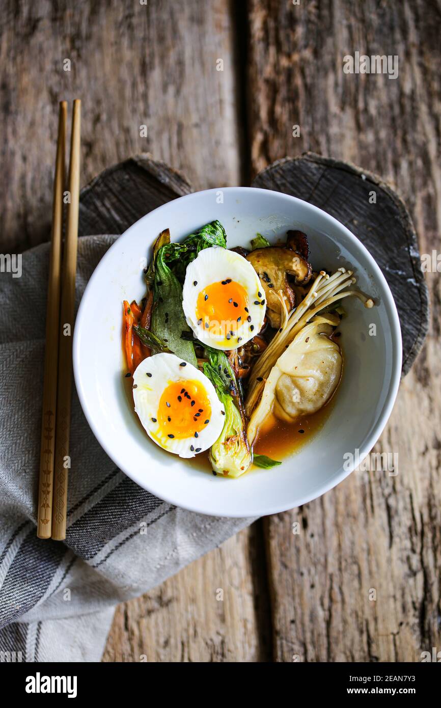 Shiitake-Brühe mit gebratenem Gemüse und Jiaozi-Knödeln Stockfoto