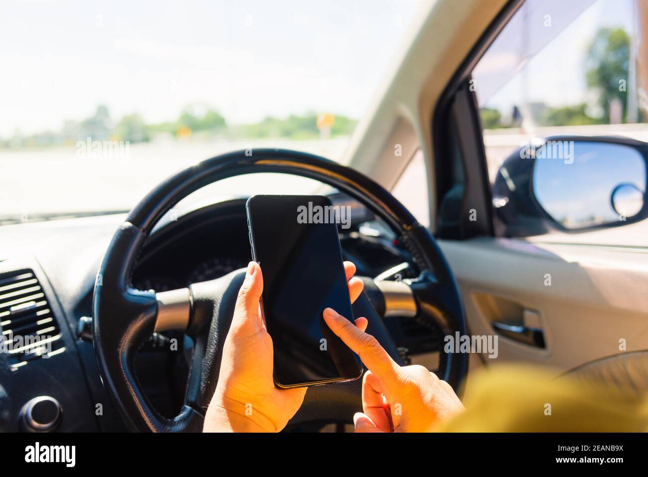 Frau in einem Auto und mit Touchscreen auf dem Handy Smartphone Stockfoto