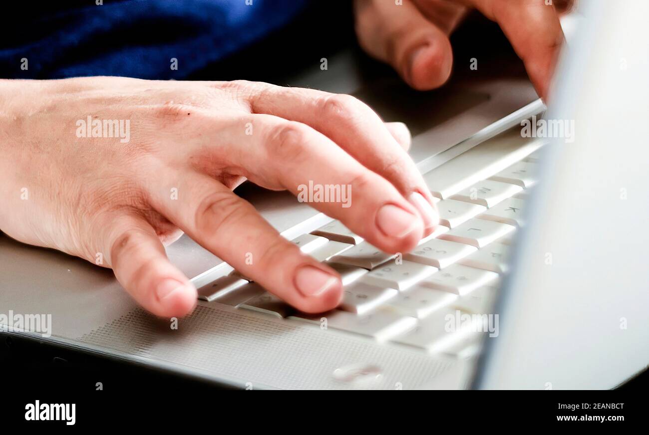 Junge kaukasische Frau auf Laptop-Tastatur eingeben. Arbeiten von ho Stockfoto