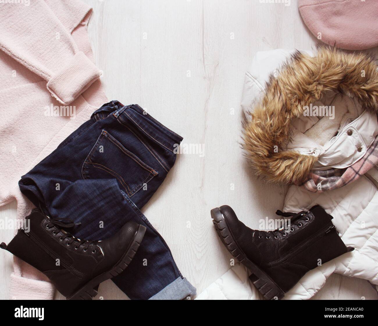 Eine Reihe von angesagten winter Frauen Kleidung. Wolle Pullover, Schuhe, Jeans, Mantel, Hut und Schal auf weißem Holz- Hintergrund. Stockfoto