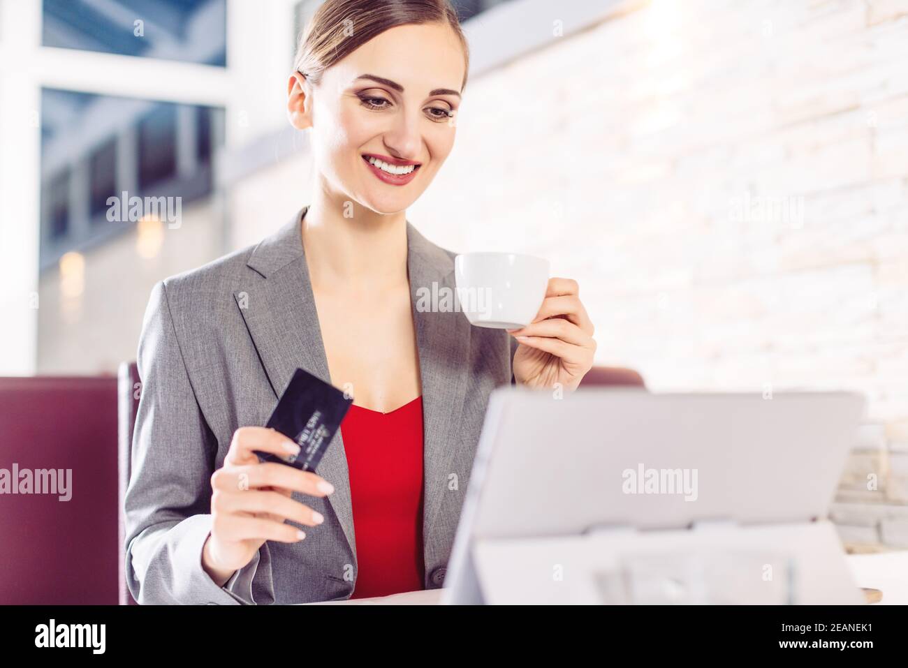 Frau im Café mit Computer, die Sachen von einer Website bestellt Stockfoto